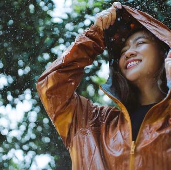 beautiful woman wearing a rain jacket during rain smiling
